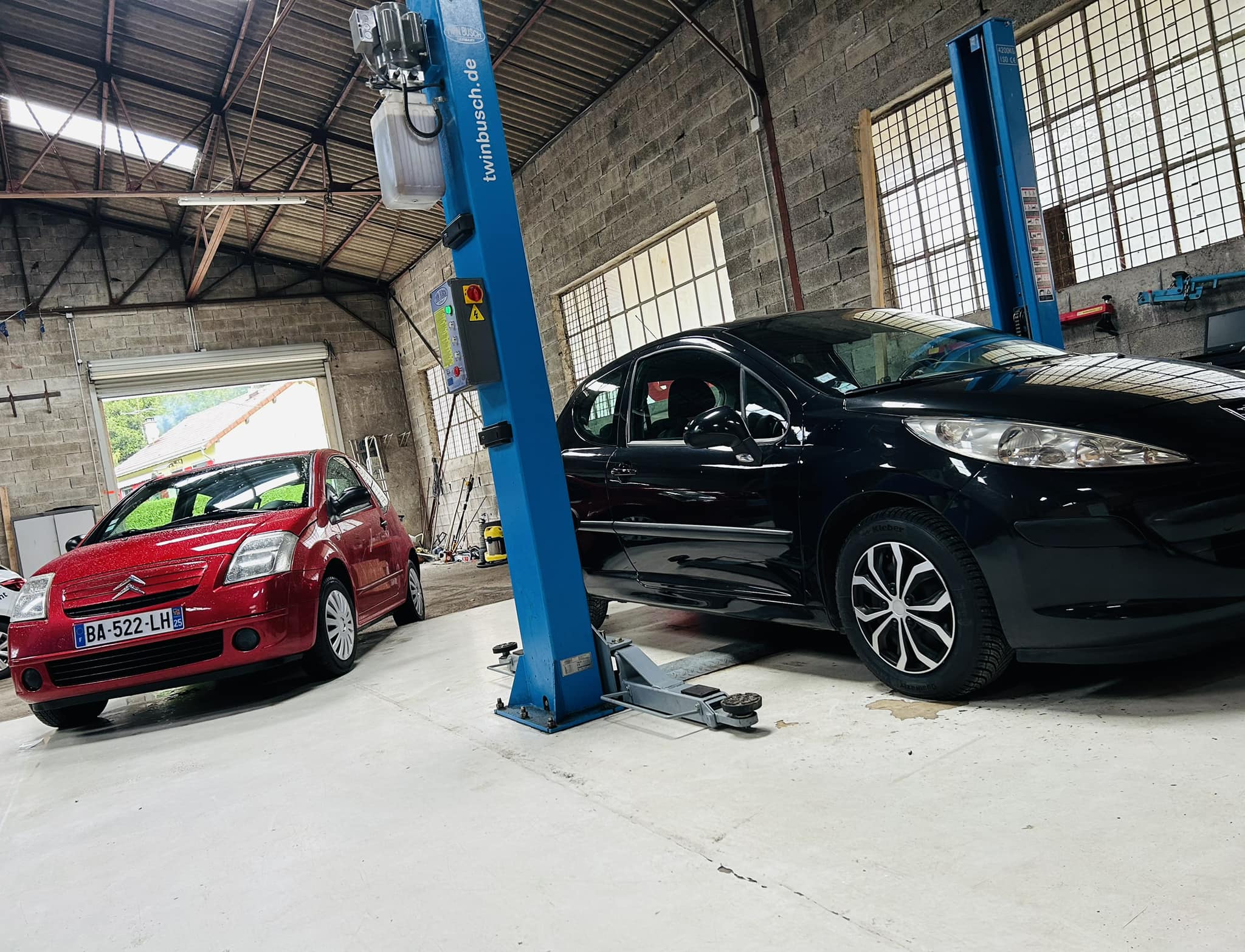 Atelier avec pont élévateur et véhicules en intervention